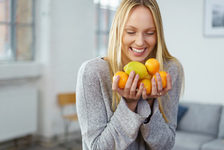 Frau mit Citrusfrüchten in den Händen