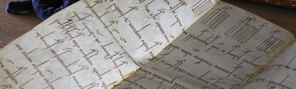 Teil einer mittelalterlichen Urkunde aus dem Archiv nebst Lupe und Kordel.