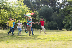 6 Kinder, die zusammen über eine Wiese laufen © AdobeStock WavebreakmediaMicro